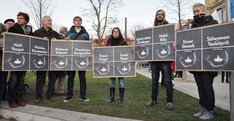 Teilnehmer der GeDenk-Veranstaltung mit Tafeln, auf denen die Namen von 10 Opfern zu lesen sind.